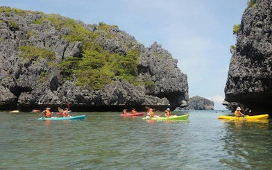 Kayakers exploring limestone cliffs at Ang Thong National Marine Park, Koh Samui.