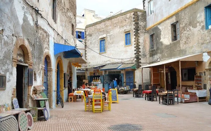 Essaouira street scene with colorful chairs and tables, Marrakech day trip.
