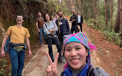 Group of tourists on a forest trail during a private car tour from Sapa to Mu Cang Chai rice terraces.