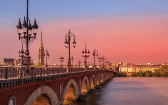 Pont de Pierre bridge over Garonne River at sunset, Bordeaux.