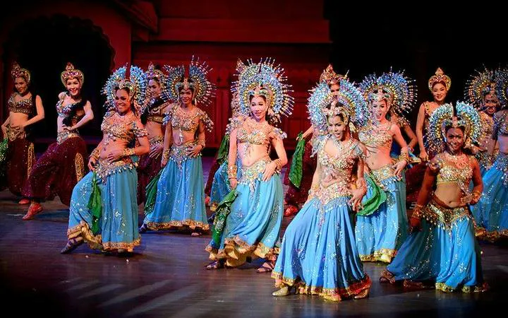 Performers in vibrant costumes dancing at Colosseum Show Pattaya, Thailand.