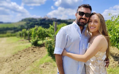 Couple enjoying vineyard view on Tuscany wine tour near San Gimignano.