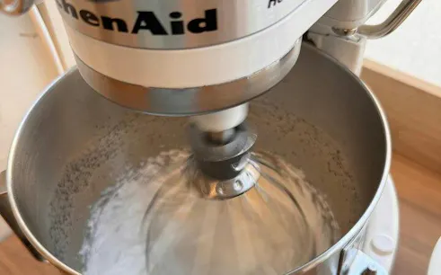 Stand mixer whisking ingredients for Paris macaron baking class with Le Cordon Bleu-trained chef.