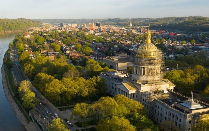 Charleston cityscape with historic capitol building and surrounding greenery.