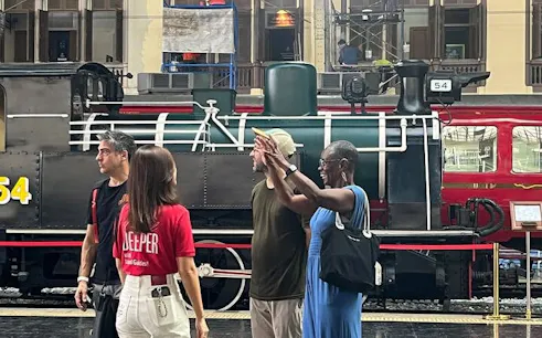 Tour group in front of historic train at Bangkok's Talat Noi during guided walking tour.