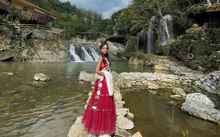 Waterfall and scenic view at Cat Cat Village, Sa Pa, with traditional attire.