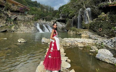 Waterfall and scenic view at Cat Cat Village, Sa Pa, with traditional attire.