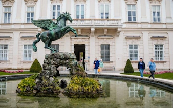 Pegasus statue in Mirabell Gardens, Salzburg, with visitors exploring nearby.