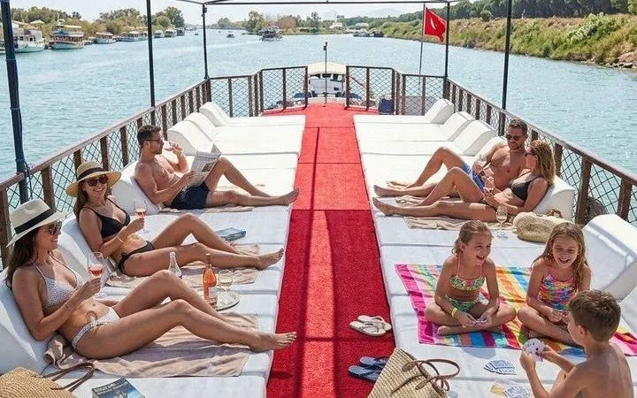 Boat tour group relaxing on deck with drinks, Antalya river view, part of Lower Duden Waterfall tour.