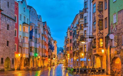 Colorful buildings lining a cobblestone street in Innsbruck during a self-guided walking tour.