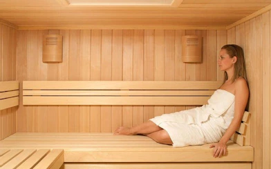Person relaxing in a wooden sauna, Hurghada Turkish bath experience.