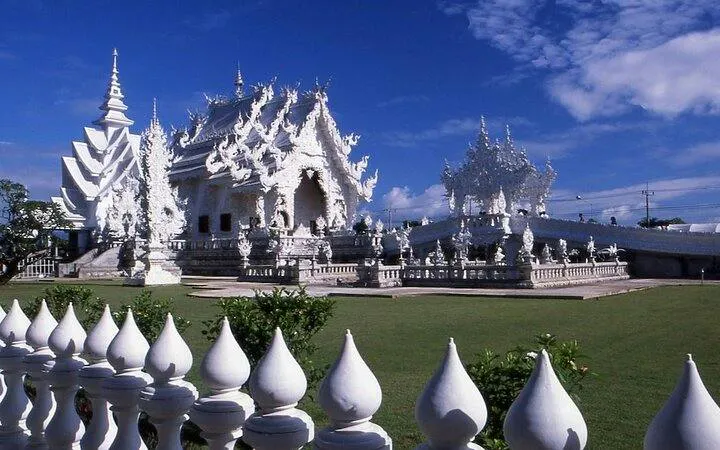 White Temple in Chiang Rai with intricate architecture under a blue sky.