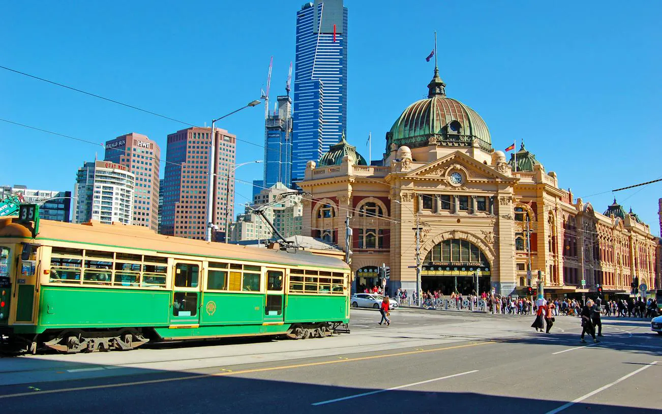 Flinders Street Station with a green tram in Melbourne, part of the Laneways and Arcades walking tour.