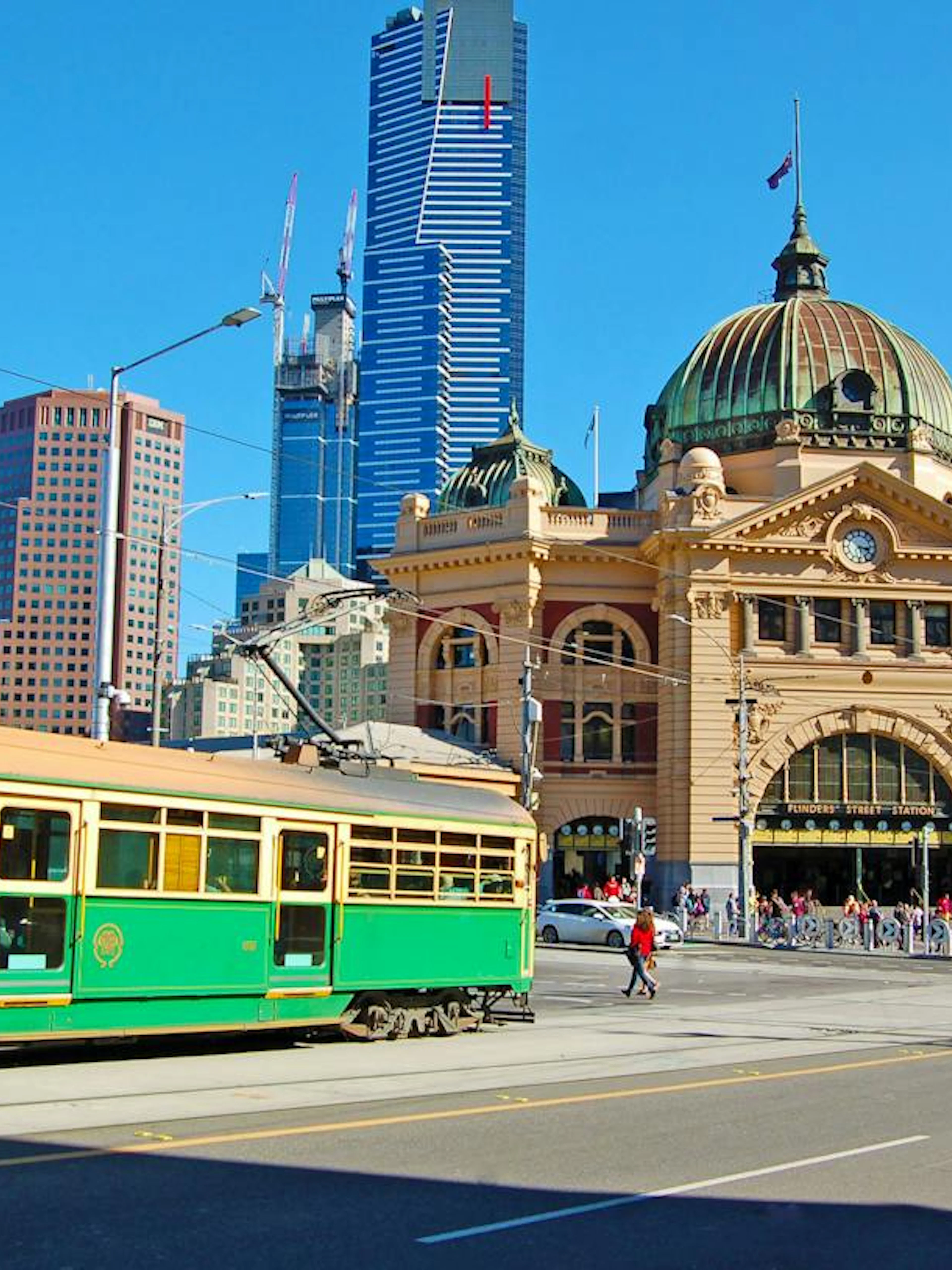 Flinders Street Station with a green tram in Melbourne, part of the Laneways and Arcades walking tour.