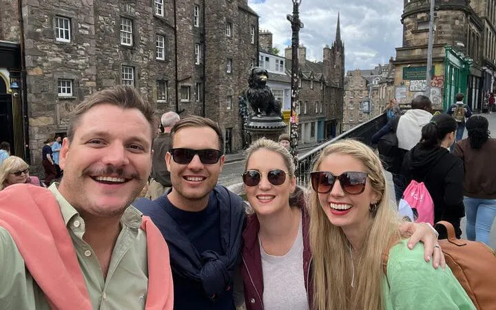 Group enjoying Edinburgh's historic streets near Greyfriars Bobby statue during self-guided city game.
