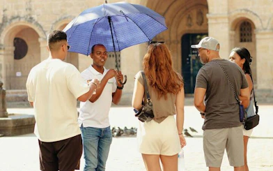 Tour guide with umbrella leading group in Santo Domingo Colonial Zone.