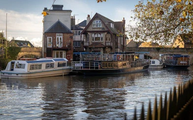 Boats docked along the river in Oxford with historic buildings in the background.