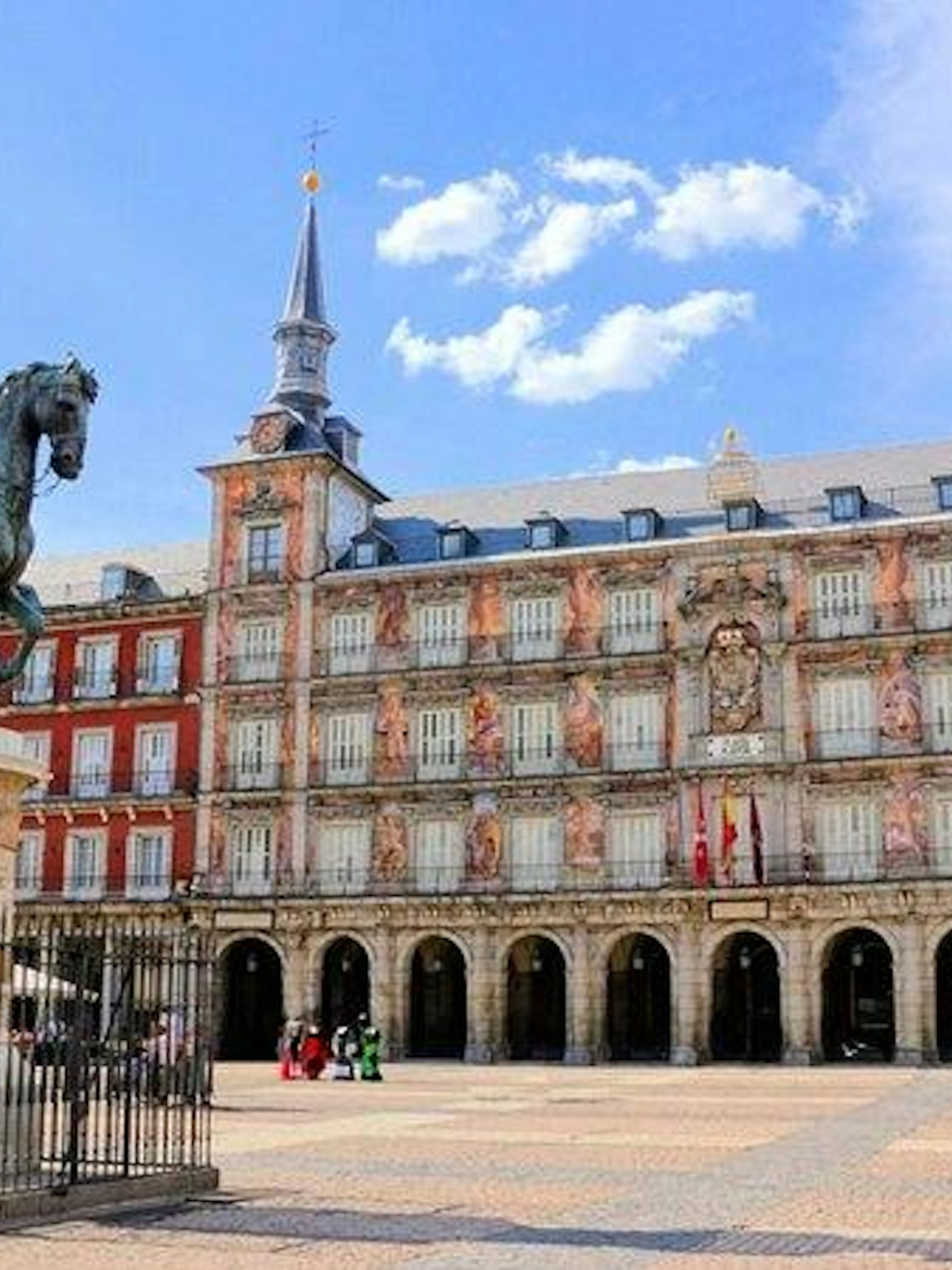 Plaza Mayor statue and historic building in Madrid, part of Don Quixote's city exploration game.