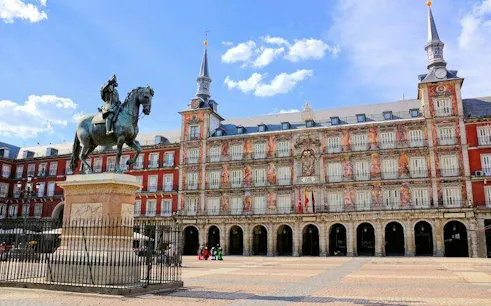Plaza Mayor statue and historic building in Madrid, part of Don Quixote's city exploration game.