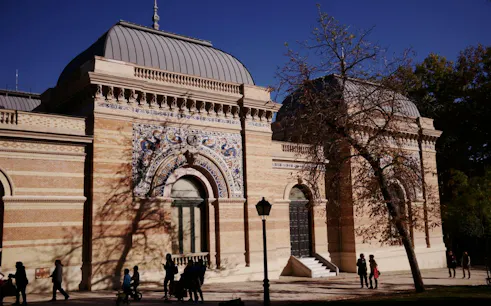 Retiro Park's Velázquez Palace with intricate facade, Madrid.