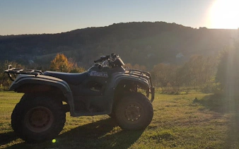 Quad bike on grassy hill during Krakow off-road tour with sunset view.
