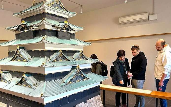 Visitors examining a model of Tokyo Castle during the Imperial Palace guided walking tour.