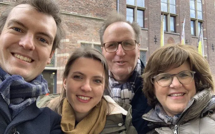 Group of people smiling in front of a historic building in Utrecht during a city exploration game.