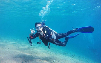 Snorkeler underwater at Tiran Island, Sharm El Sheikh, showing OK sign during sea trip.