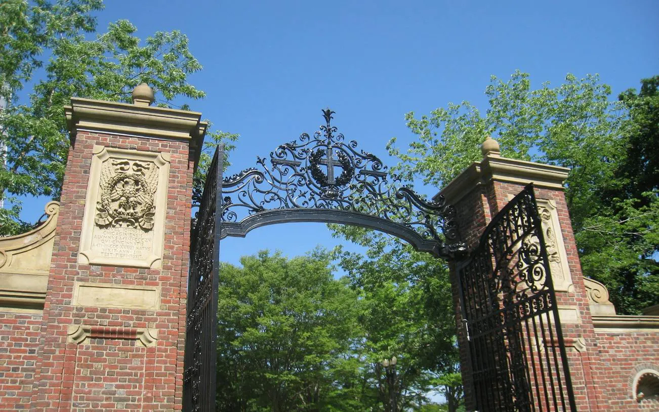 Harvard Yard gate with intricate ironwork and brick pillars, Boston.