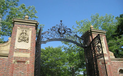 Harvard Yard gate with intricate ironwork and brick pillars, Boston.