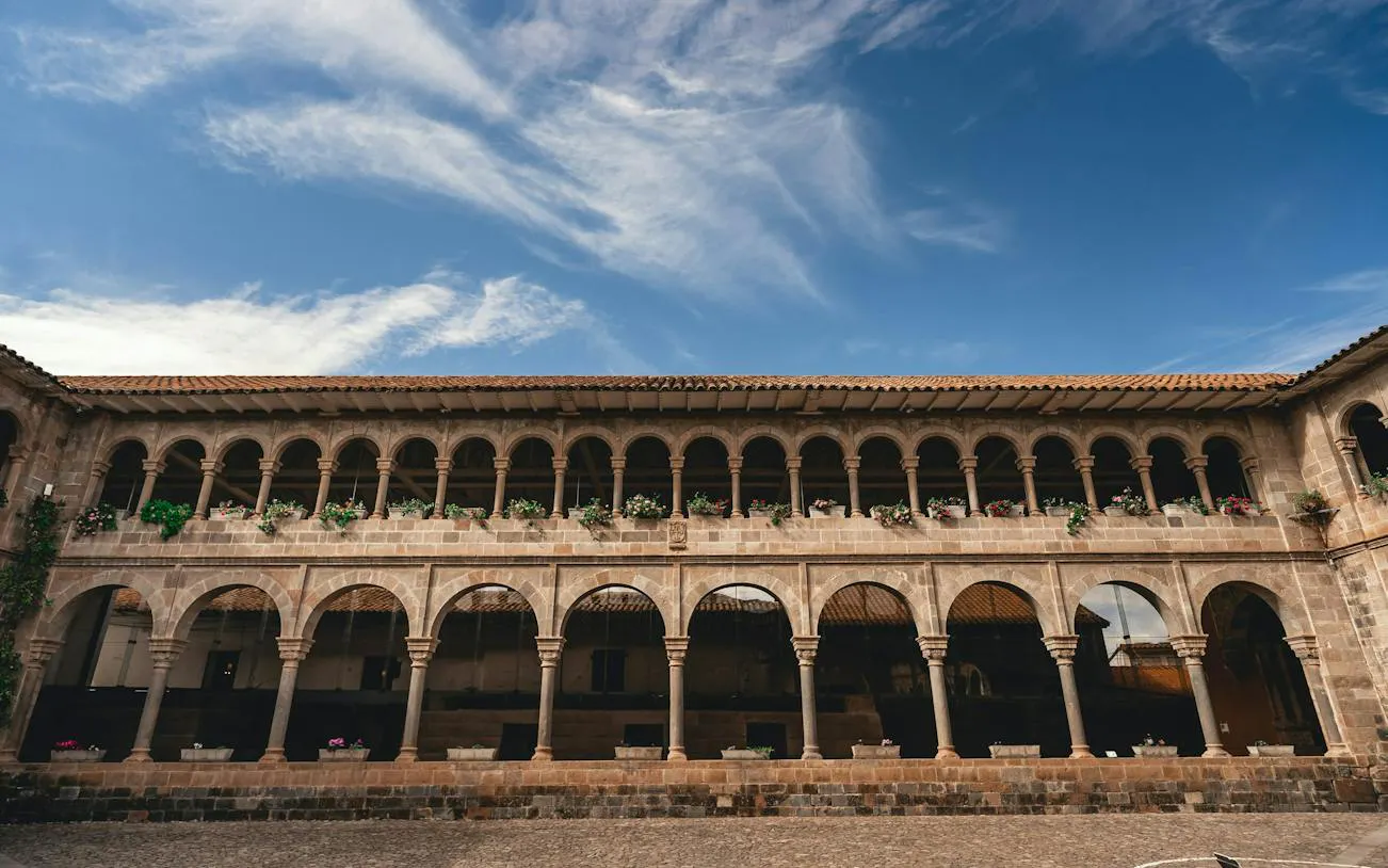 Stone arches and courtyard in Cusco Historic Center, part of a self-guided audio walking tour.