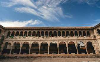 Stone arches and courtyard in Cusco Historic Center, part of a self-guided audio walking tour.