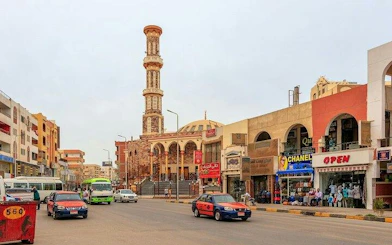 Street view in Hurghada with mosque and shops, part of private guided tour.