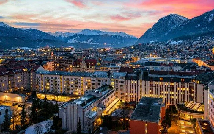 Innsbruck cityscape at sunset with mountains in the background, viewed during self-guided walking tour.