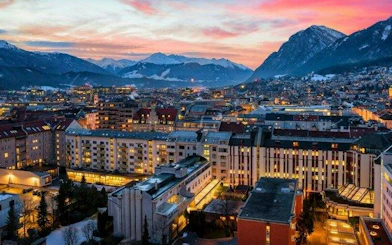 Innsbruck cityscape at sunset with mountains in the background, viewed during self-guided walking tour.