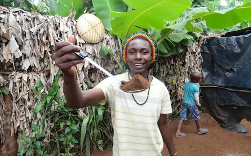 Person holding coffee grounds at Materuni Coffee Farm, Arusha tour.
