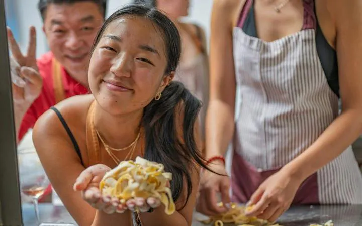 Participants making pasta during a cooking class in Florence.