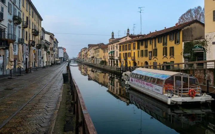 Navigli canal with boat and colorful buildings in Milan, Italy.