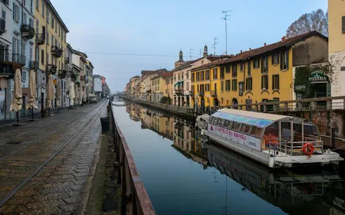 Navigli canal with boat and colorful buildings in Milan, Italy.