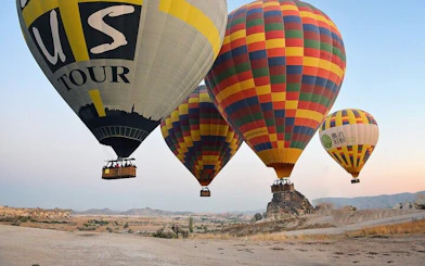 Hot air balloons floating over Cappadocia's unique rock formations at sunrise.