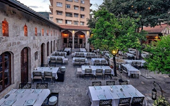 Outdoor dining area in a historic courtyard in Turkey, set for a Turkish cuisine tour.