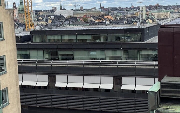 Rooftop view of Stockholm cityscape with modern buildings and historic architecture.