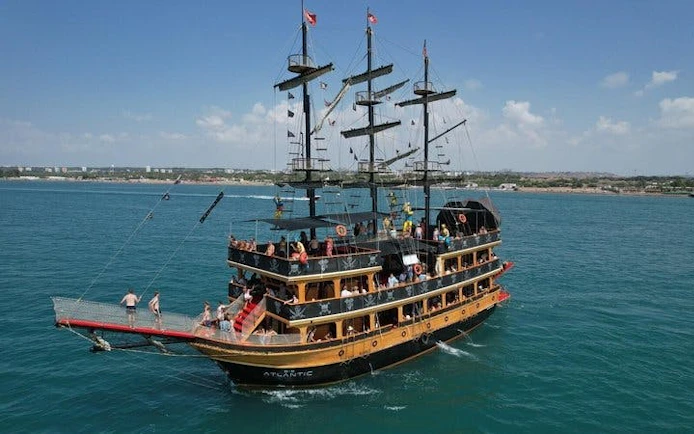 Pirate-themed boat cruise in Antalya with people enjoying the deck.