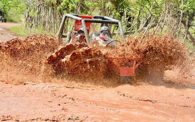 Buggy driving through muddy terrain in Punta Cana during Taino Park adventure tour.
