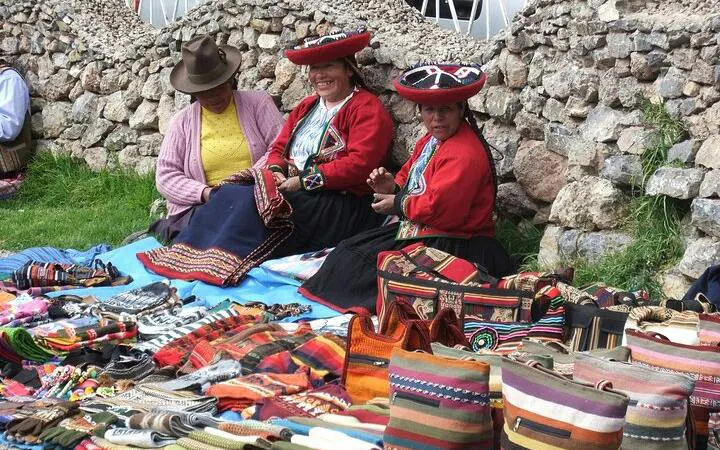 Artisans selling traditional textiles at Pisac market, Sacred Valley tour, Cusco.