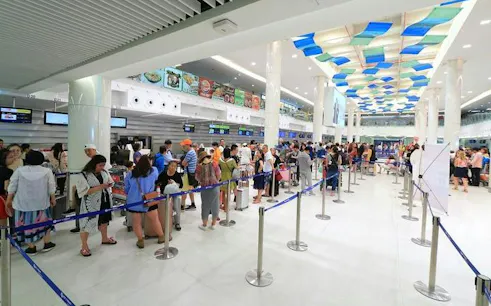 Travelers in line at Koh Samui Airport for fast-track immigration service.