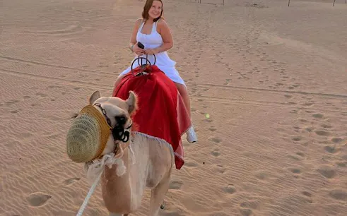 Camel ride in Abu Dhabi desert during safari tour.