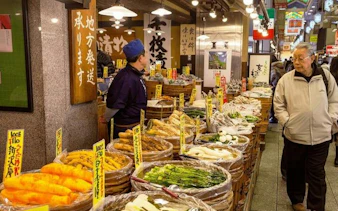 Stalls with pickled vegetables at Kyoto Nishiki Market during guided walking tour.