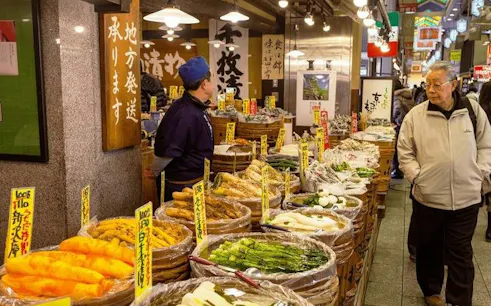 Stalls with pickled vegetables at Kyoto Nishiki Market during guided walking tour.