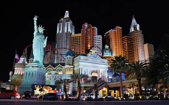 Las Vegas Strip at night with New York-New York Hotel and Casino replica landmarks.